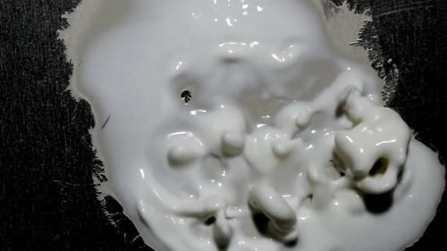 A gelatinous blob-like alien mass moves its protuberances, casting off its spawn.