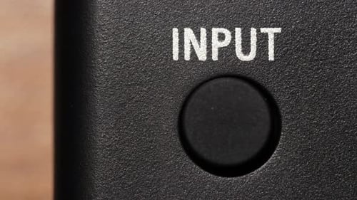 Close-up of Finger Pushing Button on Electronic Device