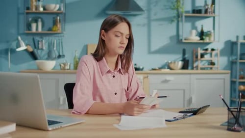 Frustrated Young Woman Accountant Use Calculator to Check Sums in Annual Report
