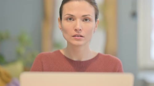 Close Up of Beautiful Woman Shaking Head in Rejection while Working on Laptop