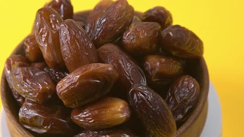 Dates in Bowl on Yellow Background