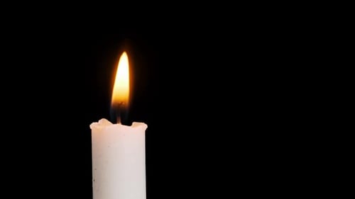 One Candle Burning and Extinguished on a Black Background Copy Space