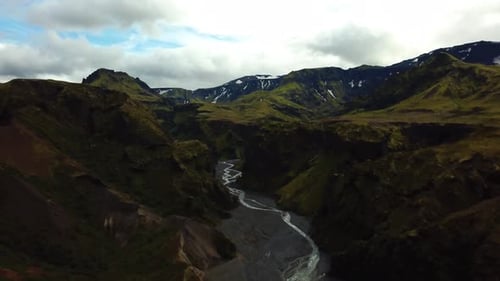 Aerial panoramic landscape view of a river flowing through a mountain valley, in the Fimmvörðuháls a