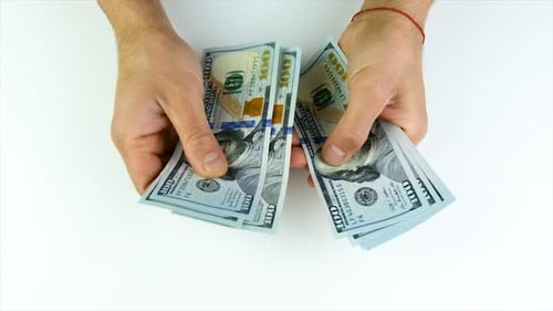A Man Counts Dollars in His Hands