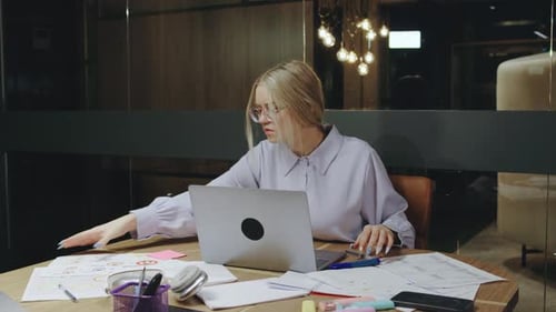 Young Adult Works With Laptop in Modern Office