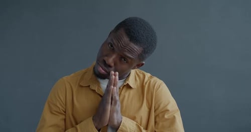 Close Up of Man Pleading with Hands Together