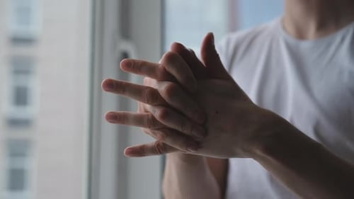 Nahaufnahme männlicher Hände, die weiße Feuchtigkeitscreme in trockene Haut einreiben Nahaufnahme der Handbehandlung