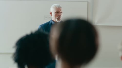 Vista posterior de los estudiantes en el aula escuchando a un profesor destacado dando una conferencia. Respeto
