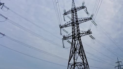 Electrical Towers and Power Lines Against Cloudy Sky