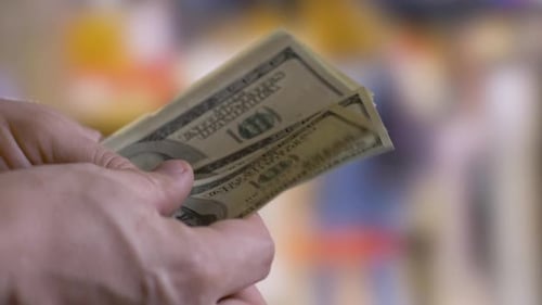 Person Holding and Counting Us Dollar Bills