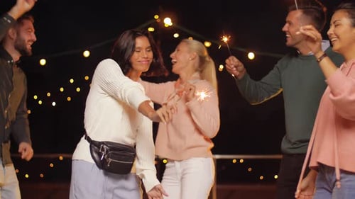 Friends Celebrate with Sparklers at Nighttime Event