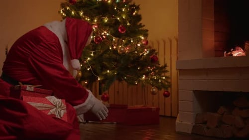 Santa Claus Putting Gifts Under Christmas Tree