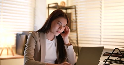 Woman Working on Laptop at Desk With Headache
