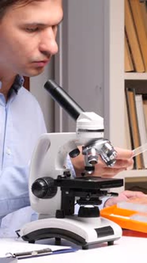 Scientist Examining Sample With a Microscope