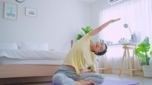 Woman Practices Yoga in Bright Bedroom