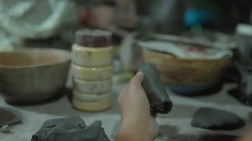 Hands shaping clay in a pottery workshop, close-up shot