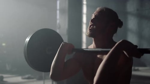 Muscular Athlete Lifting Barbell in Sport Club. Closeup Male Bodybuilder Exercise Squat