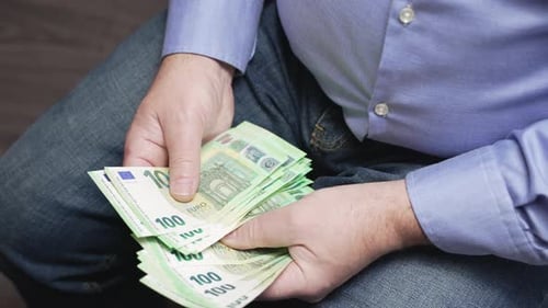 Man Counting Stack of 100 Euro Banknotes