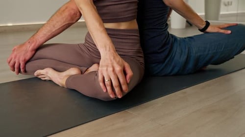 close-up man and woman practice meditation and stretching in yoga hall for body balance