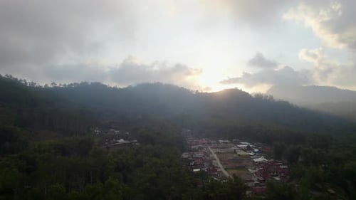 Mountain village at sunset with dramatic clouds and sun rays