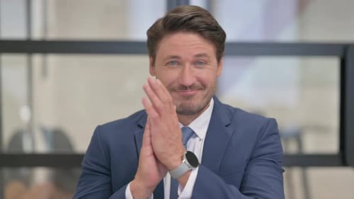 Porträt eines Geschäftsmannes mittleren Alters, der für das Team klatscht