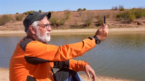 Adult Man with Phone by a Lake