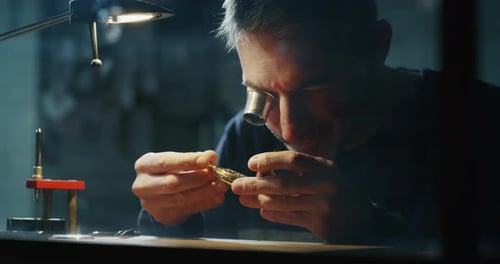 Man Fixing Golden Watch at Desk