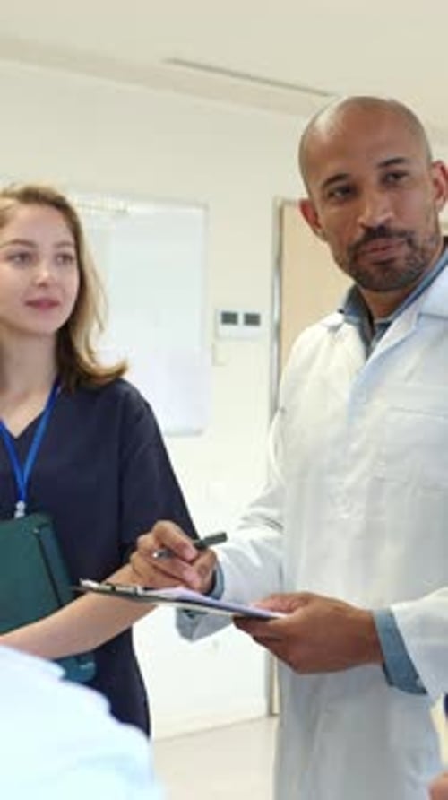 Medical Team Discussing Patient Information in Hospital Corridor