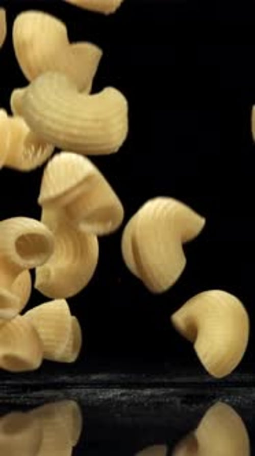 Dry Pasta Falls on the Black Table Filmed on a Highspeed Camera at 1000 Fps