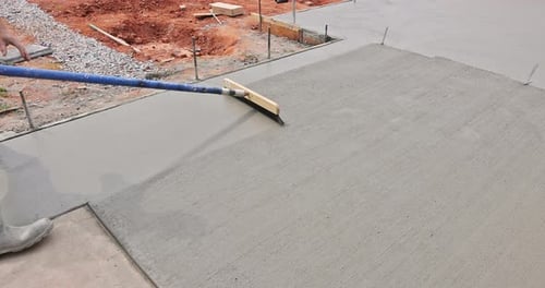 Construction Worker Smoothing Wet Concrete Surface with Tool