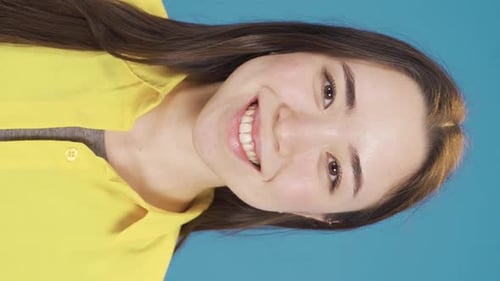 Vertical Video of Smiling young Asian woman looking at camera fun and happy.