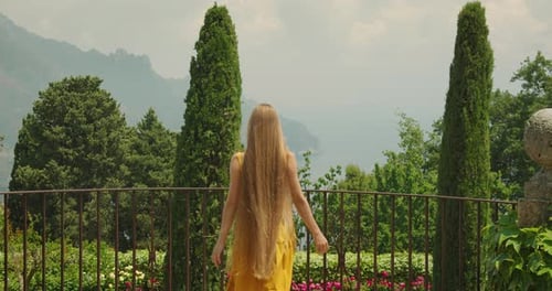 Woman with Long Hair on Balcony Overlooking Tropical Scenery