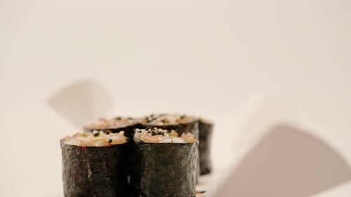 Close-up of maki roll with avocado with soy sauce in sushi delivery box on white background