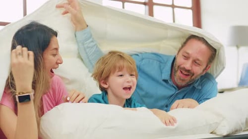 Cheerful Family Playing Together Under White Duvet