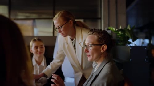 Side View of a Confident Middleaged Blonde Girl in Glasses and a Business Uniform Talking with Her