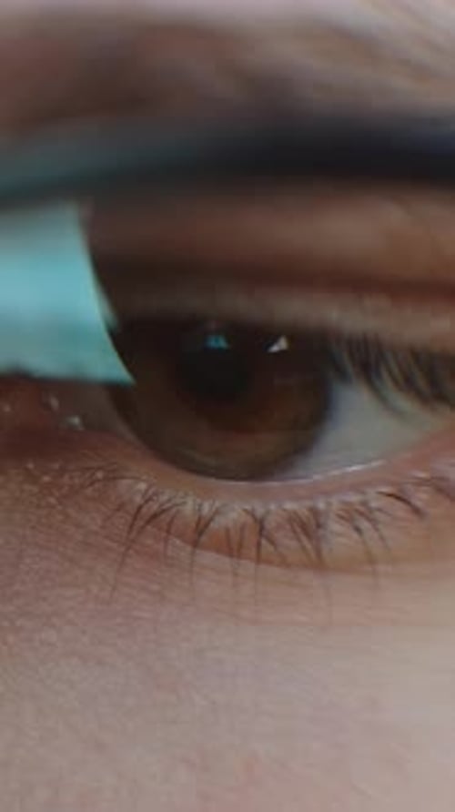 Très gros plan d'un œil brun humain portant des lunettes capturant des cils délicats, la texture de la peau et