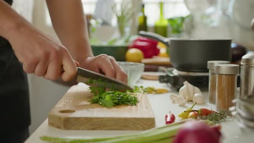Adult Chopping Fresh Herbs in Kitchen