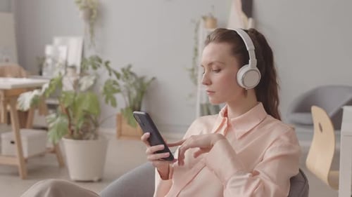 Young Woman Listening to Music in Headphones in Office