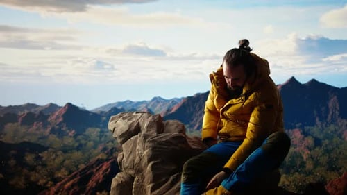 Determined Climber Standing at the Summit Enjoys Peaceful Moment