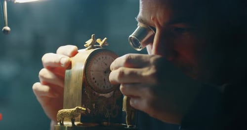 Slow motion close up of a professional watchmaker repairer working on a vintage mechanism clock in