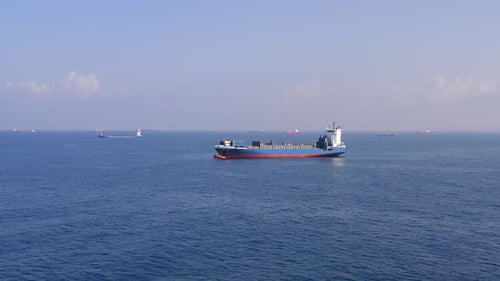Aerial footage of a container ship approaching a commercial port.