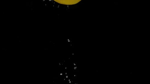 Bright Yellow Lemon Plunges Into Water on Black