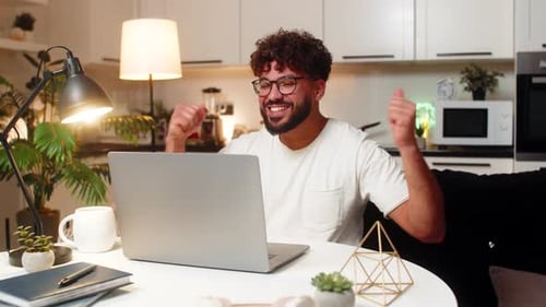 Man Working on Laptop in Modern Apartment at Desk
