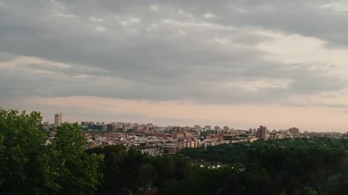 A wide sunset view of Madrid Spain shows the city skyline under soft evening light