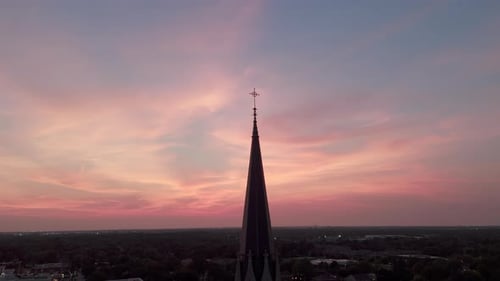 The Silhouette of the Cross and Church Bell Tower in Sunrise Sunset Time Aerial Shot