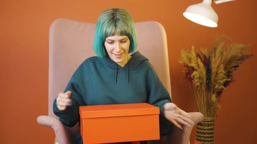 Woman Opens Present in Orange Gift Box