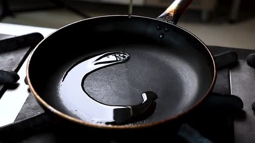 Oil Being Poured into a Frying Pan