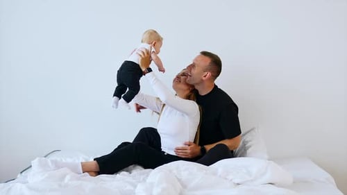 Happy Family Playing with Baby on Bed