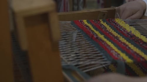 Hands Weaving Colorful Fabric on Traditional Loom