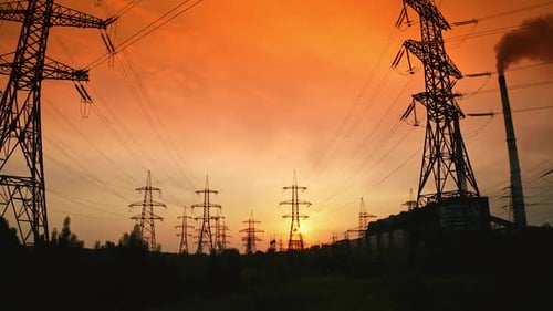 Transmission lines under red evening sky.